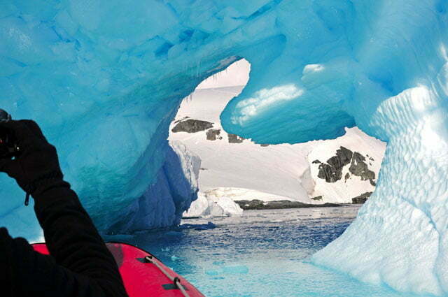 De bote entrando no túnel formado pelo iceberg