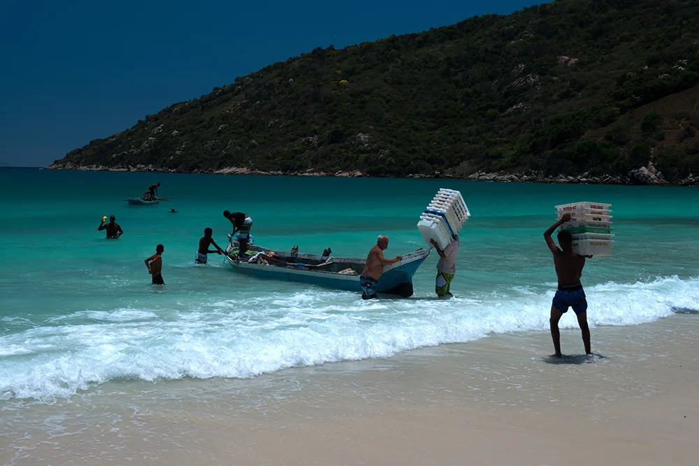 imagem de pescadores e-canoa-na praia em Arraial do Cabo