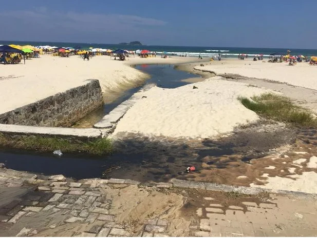 Litoral de São Paulo e saneamento, imagem de vazamento de esgoto na praia de Enseada, Guarujá