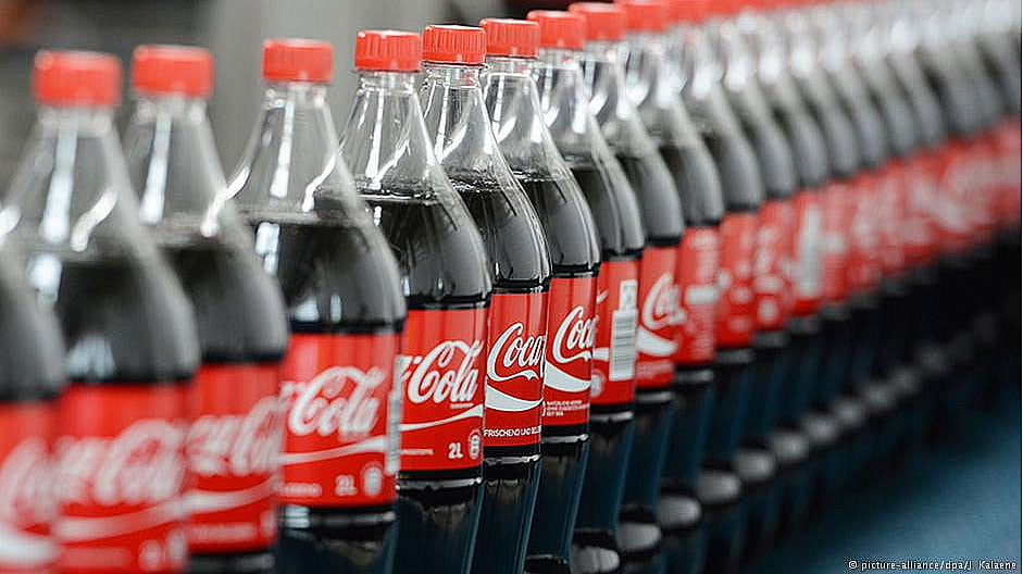 imagem de garrafas de coca cola na linha de produção