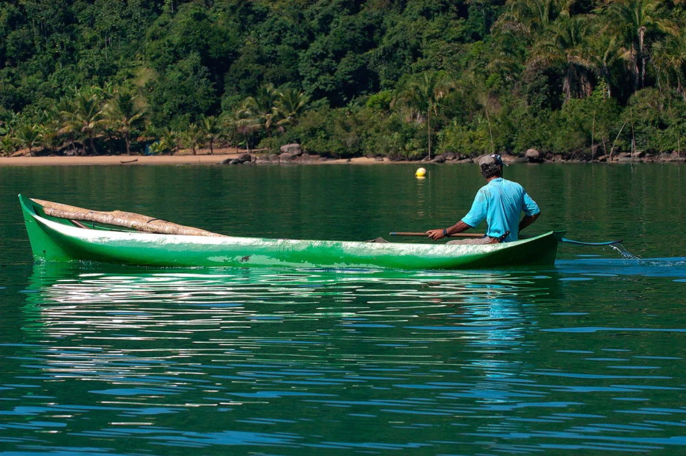 imgem de pescador em canoa no saco de mamanguá, paraty