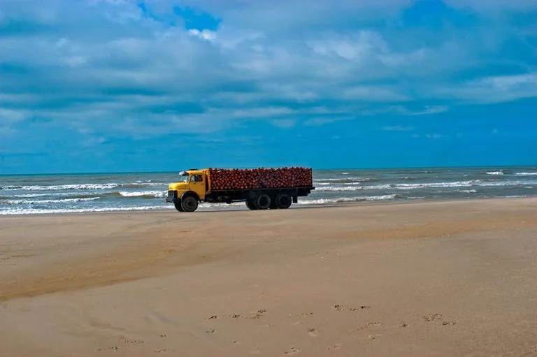 imagem de caminhão carregado na praia