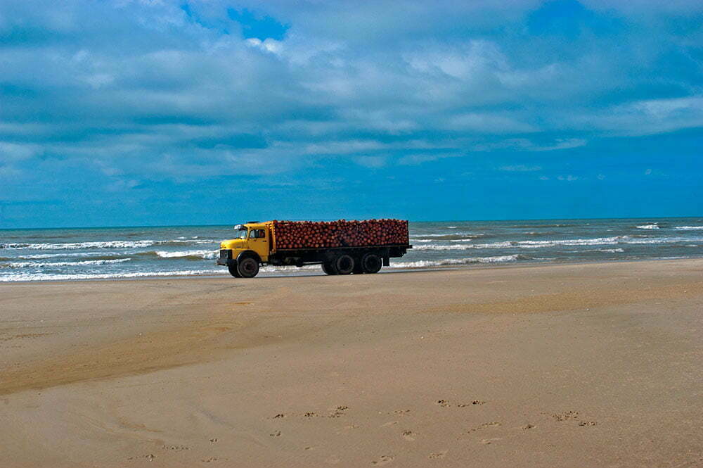 imagem de caminhão carregado na praia