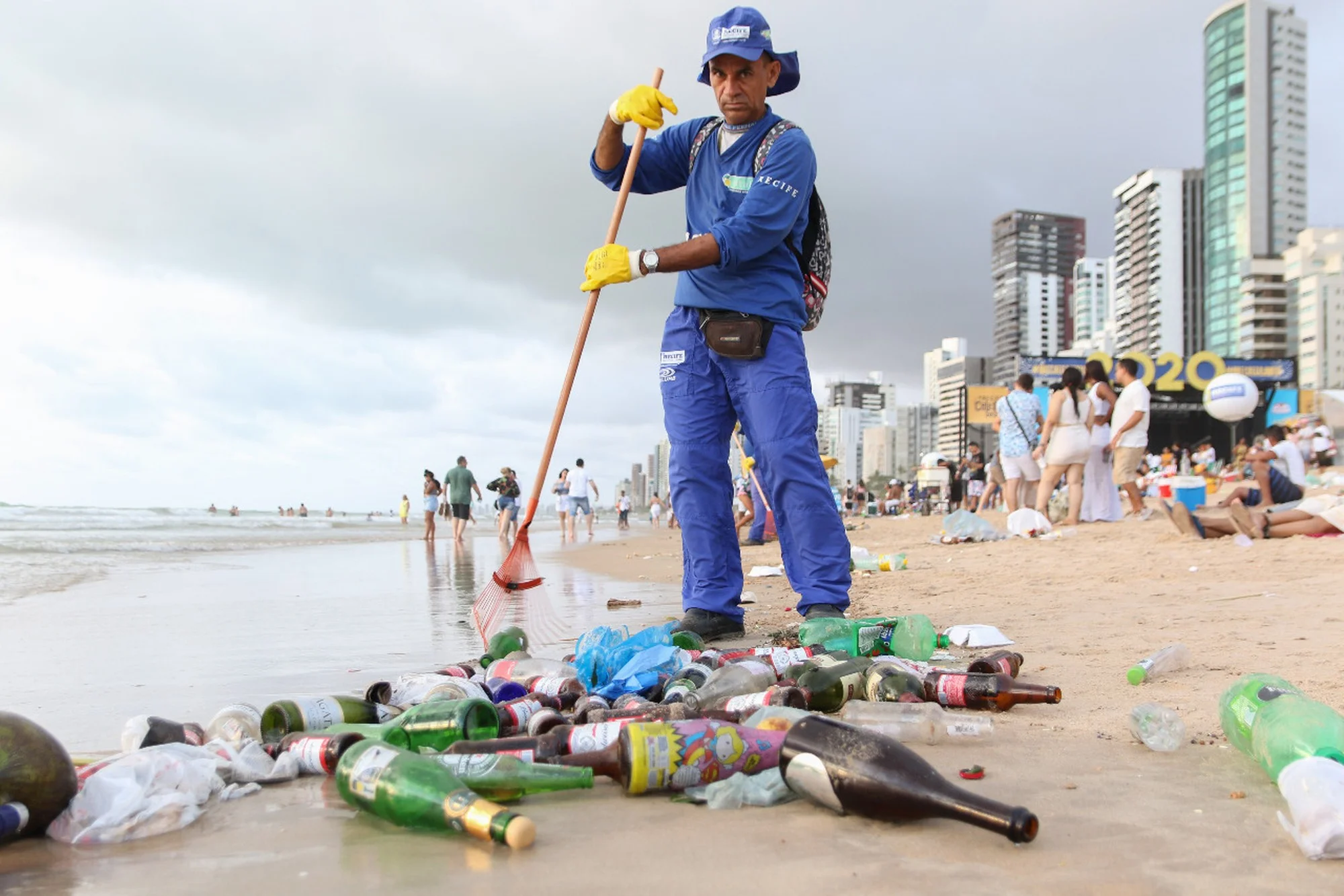 imagem de gari limpando lixo em praia do Recife