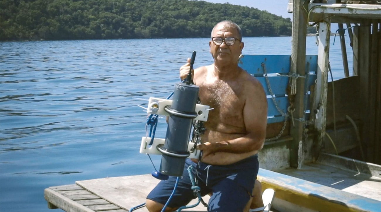 Imagem de pescador com hidrofone pesquisando as toninhas