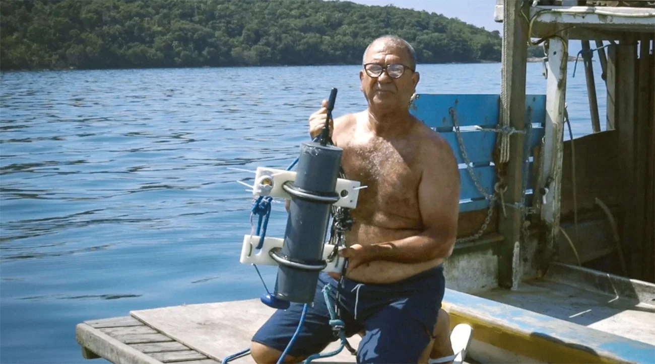 Imagem de pescador com hidrofone pesquisando as toninhas