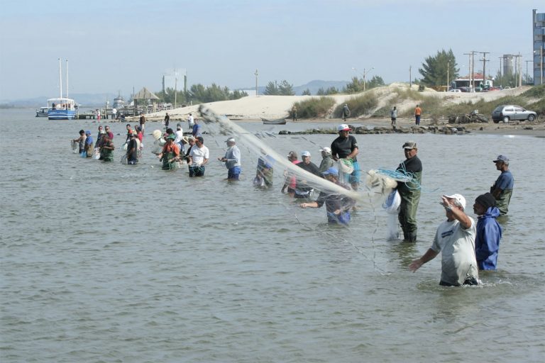 Imagem de pescadores artesanais em Laguna a espera dos botos