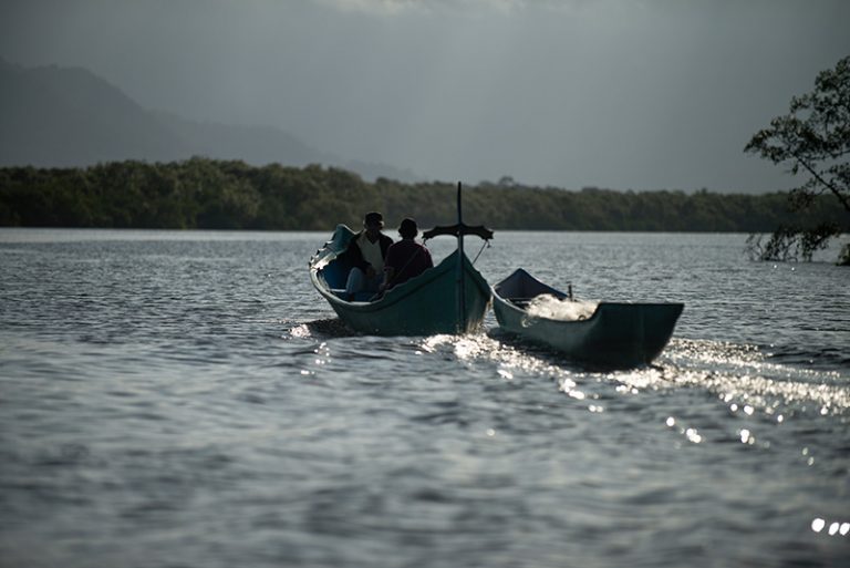 Canoa de bordadura reboca uma canoa de pau.